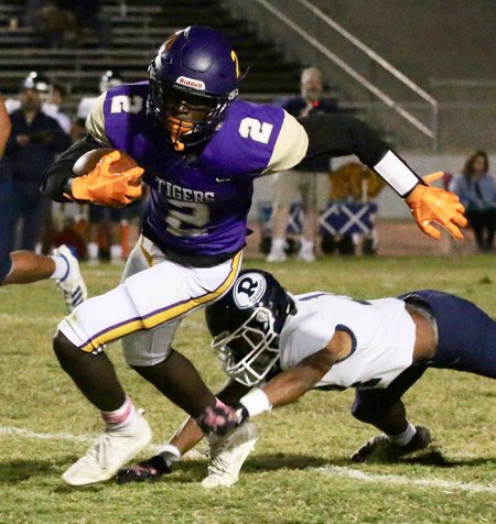 Lemoore's Chris Taylor runs for a short gain during Friday night's football game in Tiger Stadium.